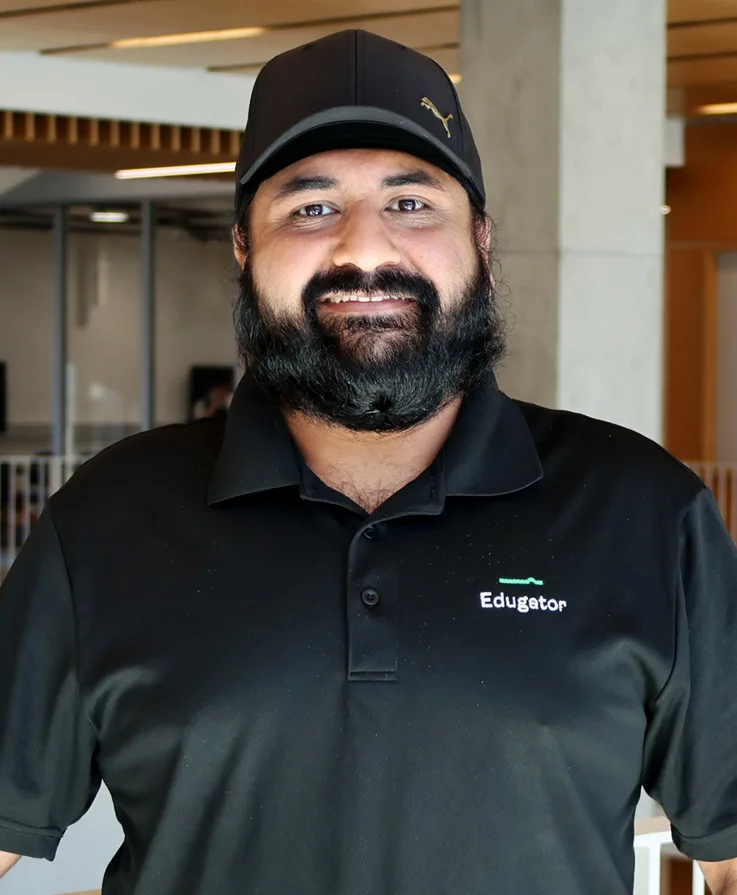 Kapoor wearing a black baseball cap and a black polo shirt.